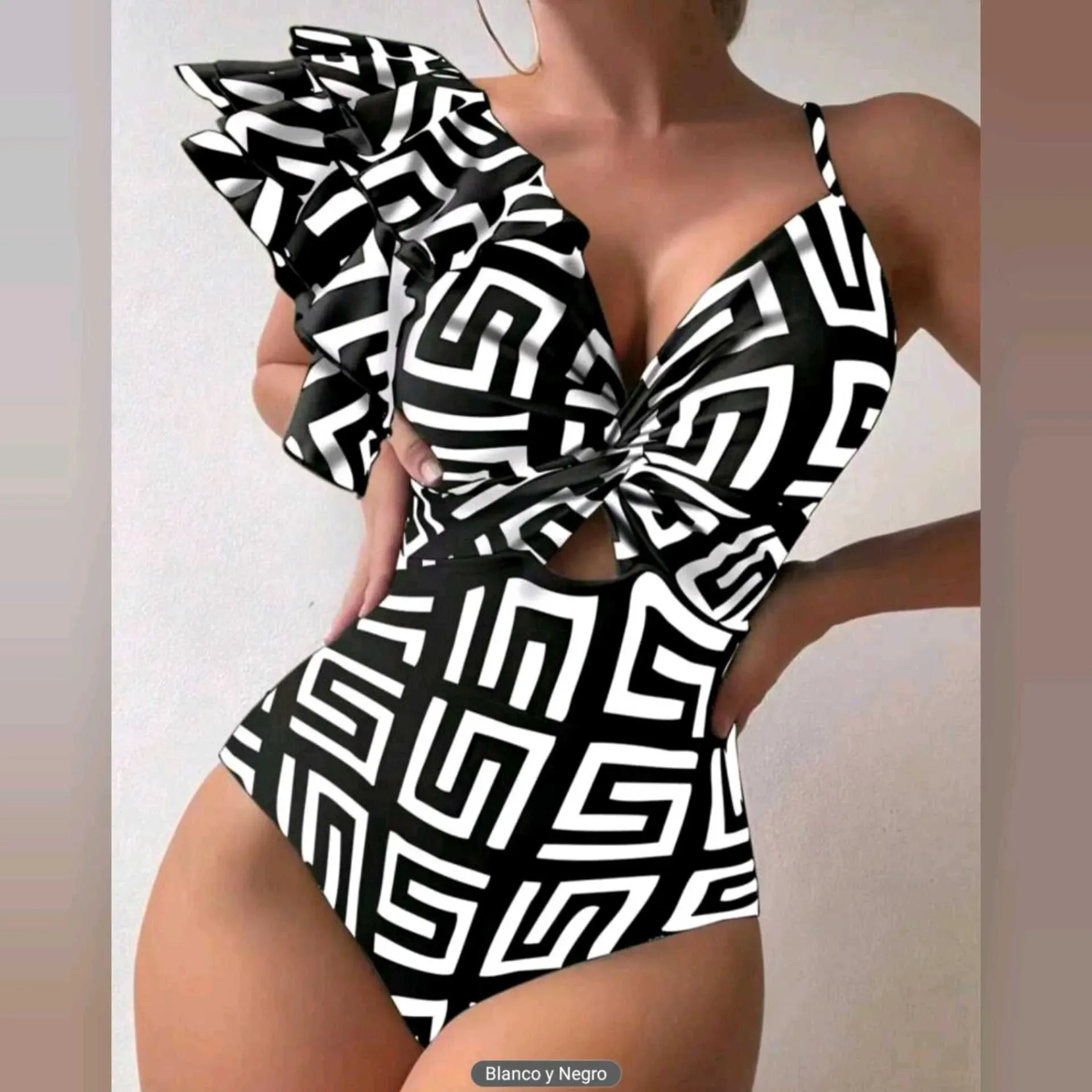 👙 Traje de Baño de una Pieza con Estampado y Volante Asimétrico 👙✔ Diseño de una pieza con estampado geométrico moderno.✔ Volante asimétrico en un hombro que aporta elegancia y estilo.✔ Escote en “V” con detalle de nudo central que realza la figura.✔ Ti